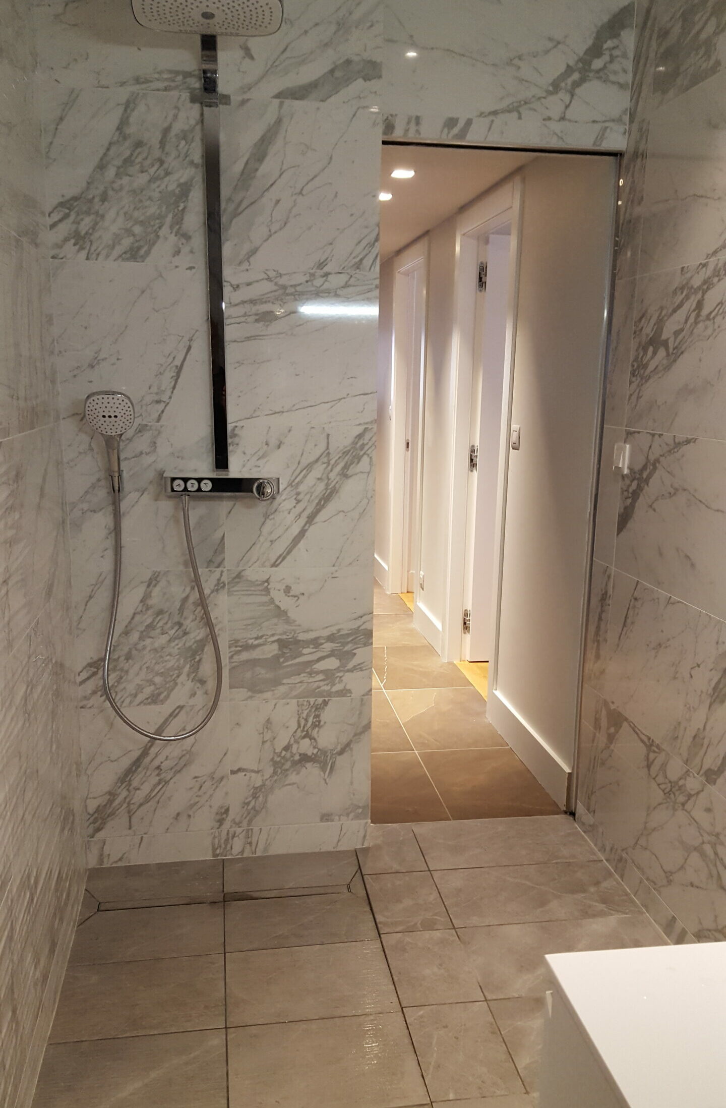 Pose de carrelage Salle de bains moderne avec douche à l’italienne et carrelage effet marbre blanc veiné à Lyon