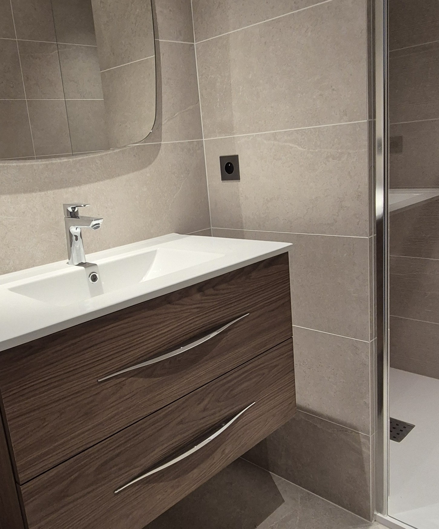 Pose de carrelage Salle de bains moderne avec carrelage effet pierre beige, meuble en bois foncé et douche à l'italienne à Lyon
